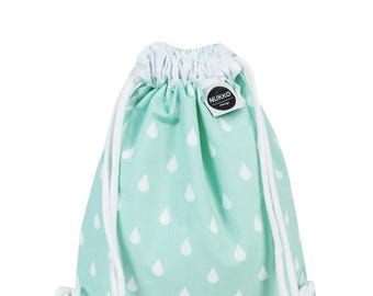 Könnte beinhalten: Ein mintgrüner Kordelzugrucksack mit weißem Regentropfenmuster. Die Tasche hat weiße Kordelzüge und einen weißen, gerafften oberen Rand. Ein kleines Etikett mit dem Text "NUKKO design" ist angebracht.