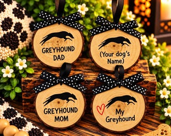 Può includere: Quattro ornamenti rotondi in legno con bordi in corteccia, ognuno con una silhouette nera di un levriero in corsa. Gli ornamenti hanno fiocchi a pois bianchi e neri e ganci neri. Il testo include Greyhound Dad, Your dog's Name, Greyhound Mom e My Greyhound con un cuore rosso.