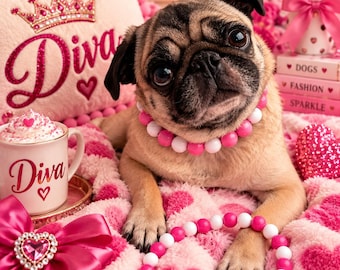May include: A fawn pug wearing a pink and white beaded collar, resting on a pink heart-patterned blanket. Nearby is a mug labeled Diva, a pillow with a crown and the text Diva, and a beaded necklace. The scene includes pink roses and books.
