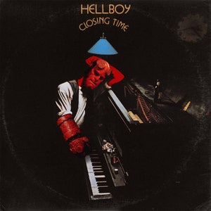 Peut inclure: Un homme à la peau rouge et aux cornes est assis à un piano noir avec un abat-jour bleu au-dessus de lui. Le texte "HELLBOY CLOSING TIME" est en haut de l'image.