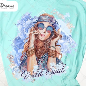 May include: A turquoise t-shirt with a watercolor design of a woman with long brown hair wearing round sunglasses and a headband. The woman is surrounded by blue flowers and the text "Wild Soul" is printed below her.