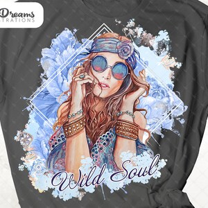 May include: A gray t-shirt with a watercolor design of a woman with long brown hair wearing a headband and sunglasses. The design includes blue flowers and the text "Wild Soul".