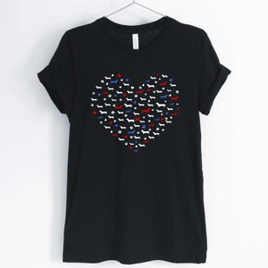 May include: Black t-shirt with a red, white, and blue heart design made up of dachshund silhouettes.