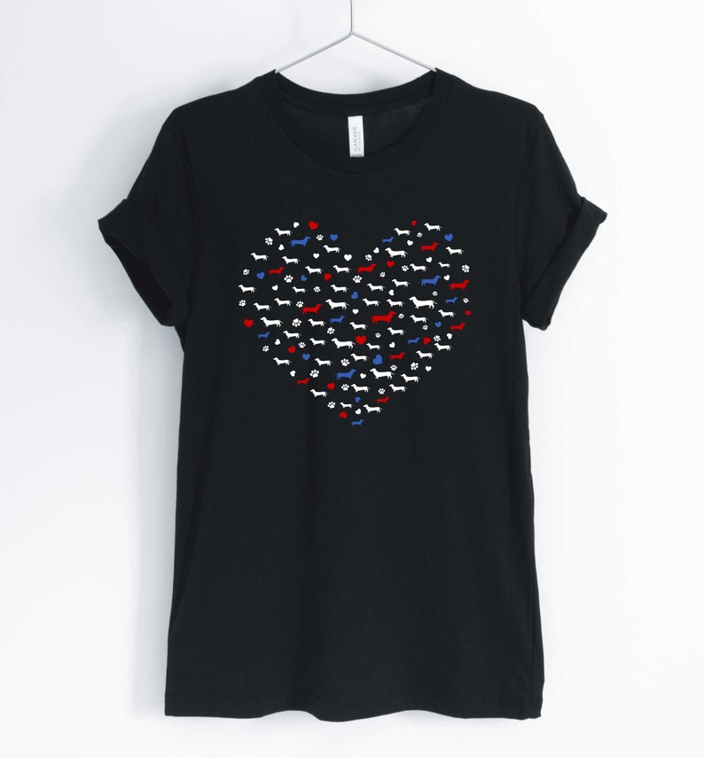 May include: Black t-shirt with a red, white, and blue heart design made up of dachshund silhouettes.