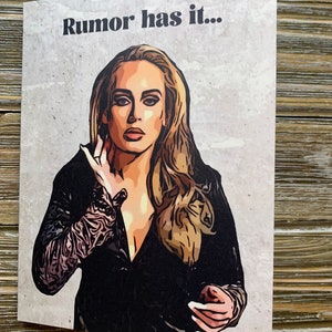 May include: A greeting card with a cartoon illustration of Adele, a singer, with the text "Rumor has it..." printed on a gray background.