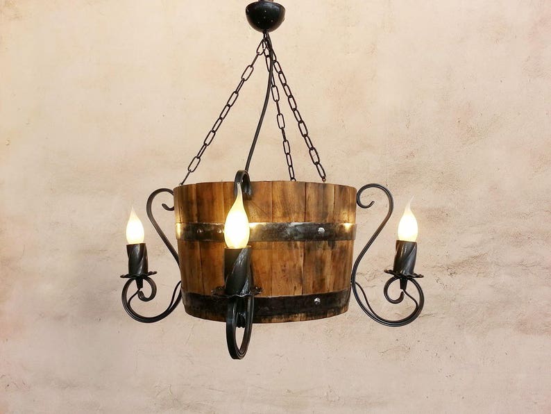 May include: A rustic wooden barrel chandelier with a black metal frame and three light bulbs. The chandelier is hanging from a chain.