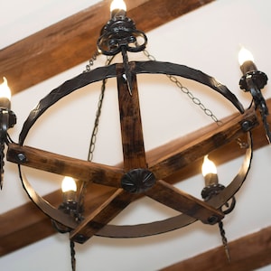 May include: A rustic chandelier with a circular metal frame and wooden spokes. The chandelier has five light bulbs and a chain hanging from the top.