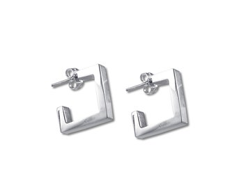 May include: A pair of silver square hoop earrings. The earrings are made of a thick metal and have a simple, modern design.