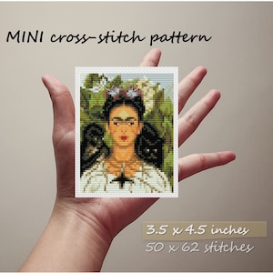 May include: A cross-stitch pattern of Frida Kahlo with two black cats, surrounded by flowers and greenery. The pattern is 3.5 x 4.5 inches and has 50 x 62 stitches.
