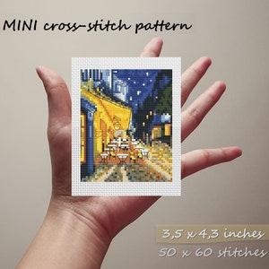 May include: A cross-stitch pattern of a cafe at night with a yellow awning, tables and chairs, and a starry sky. The pattern is 3.5 x 4.3 inches and has 50 x 60 stitches.