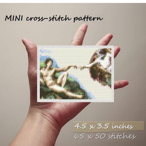 May include: A mini cross-stitch pattern featuring a detailed depiction of Michelangelo's "The Creation of Adam." The finished piece measures 4.5 x 3.5 inches and contains 65 x 50 stitches. The text "MINI cross-stitch pattern" is above the image.