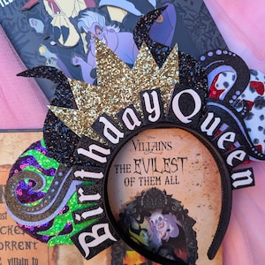 May include: Black and gold birthday headband with a crown, green and purple swirls, and the text "Birthday Queen". The headband is on top of a book with the text "Villains The Evilest of Them All".