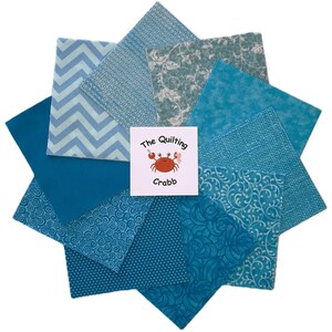 May include: A collection of blue fabric squares arranged in a starburst pattern. The squares feature various textures and patterns, including chevrons, swirls, and floral designs. A white square in the center displays the text "The Quilting Crabb" and a crab illustration.