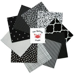 May include: A collection of black and white fabric squares arranged in a circular pattern. The fabrics feature various patterns, including polka dots, stripes, floral designs, and geometric shapes. A small card in the center displays the text "The Quilting Crabb" with a crab illustration.