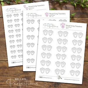 May include: Three sheets of printable royal icing transfers featuring bunny paw prints in three sizes: small, medium, and large. The sheets are white with black outlines of the paw prints.