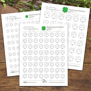 May include: Three sheets of white paper with black outlines of four-leaf clovers. The sheets are labeled "Royal Icing Transfers" and include the sizes 1", 3/4", and 1/2".