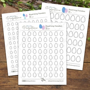 May include: Three white sheets of paper with egg-shaped outlines for royal icing transfers. The sheets have the text "BELLA'S Perfections" and "Royal Icing Transfers". Egg sizes are 1/2", 1", and 2 1/4".