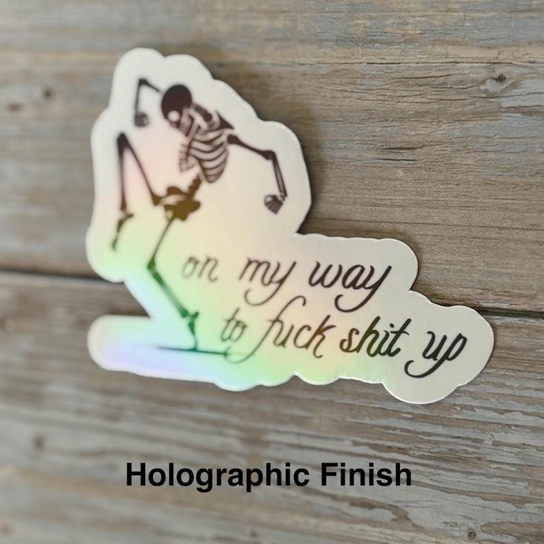 K&ouml;nnte beinhalten: Holografischer Aufkleber mit einem Skelett und dem Schriftzug "on my way to fuck shit up" in Schwarz. Der Aufkleber hat einen Regenbogeneffekt. Der Text "Holographic Finish" ist unten.