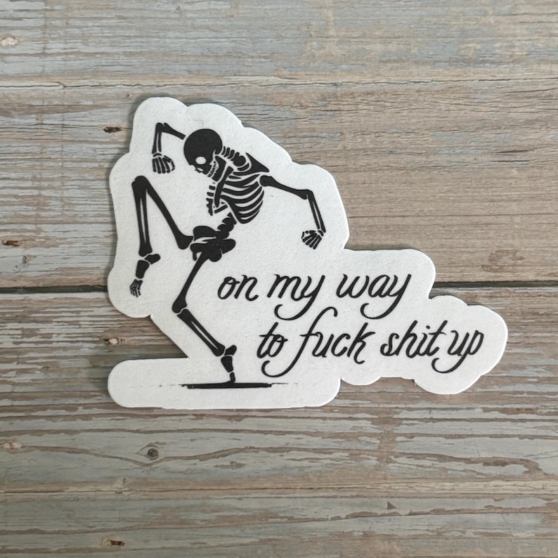 K&ouml;nnte beinhalten: Ein gestanzter Aufkleber mit einer schwarzen Skelett-Illustration in einer dynamischen Pose. Der wei&szlig;e Hintergrund zeigt den Schriftzug "on my way to fuck shit up" in einer kursiven Schrift.