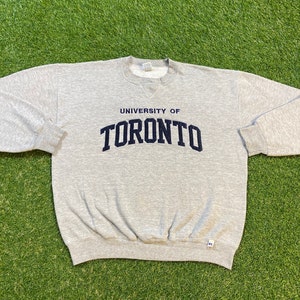 May include: Grey sweatshirt with the text "UNIVERSITY OF TORONTO" in navy blue lettering.