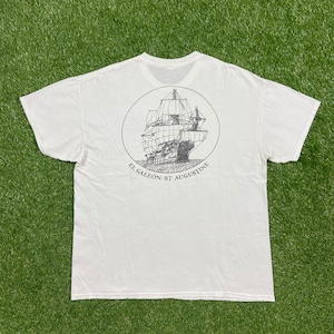 Könnte beinhalten: Weißes T-Shirt mit einer Schwarzweiß-Illustration eines Schiffes in einem Kreis mit dem Text "El Galeon St Augustine" darunter.