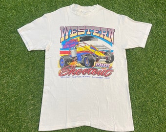 May include: White t-shirt featuring a colourful graphic of a racing car. The graphic reads "Western Shootout 1988" and "World of Outlaws".