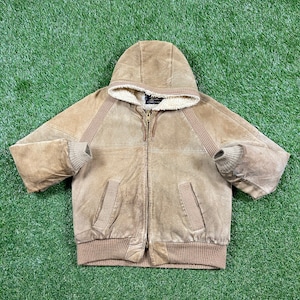 May include: A tan suede jacket with a hood and a full-length zipper. The jacket has a cream-colored, fuzzy lining in the hood and around the neck. Ribbed knit cuffs and waistband. Two front pockets. A classic outerwear piece.