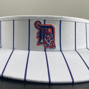 Peut inclure: Visière blanche avec des rayures bleu et blanc et un logo des Tigers de Detroit brodé sur le devant.