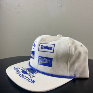 May include: White baseball cap with blue embroidered logos, including "Treflan" and "20th Anniversary Limited Edition".