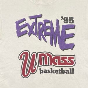May include: White t-shirt with a purple graphic that says "Extreme '95" and a red and black graphic that says "UMass basketball".