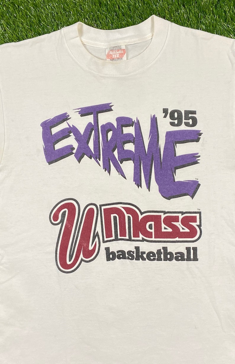 May include: White t-shirt with a purple graphic that says "Extreme '95" and a red and black graphic that says "UMass basketball".