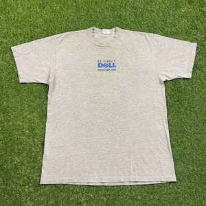 Op de afbeelding: Een grijs T-shirt met een blauw Dell-logo en de tekst "Be Direct" en "www.dell.com".