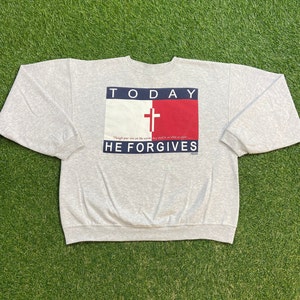 Könnte beinhalten: Grauer Sweatshirt mit einer rot-weiß-blauen Grafik mit einem Kreuz und dem Text "TODAY HE FORGIVES". Der Text "Though your sins are like scarlet, they shall be as white as snow" ist ebenfalls enthalten.