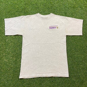 May include: A gray t-shirt with the text "Minnesota Vikings" in purple and a gold star.