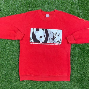 May include: Red sweatshirt with a black and white panda graphic and the text "The Cincinnati Zoo and Botanical Garden, Panda '88".