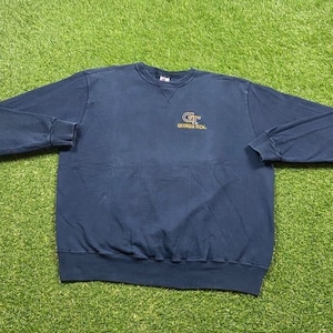 May include: A navy blue sweatshirt with a gold embroidered "GT" logo and the text "Georgia Tech."