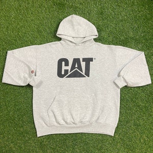 May include: A gray hooded sweatshirt with a black CAT logo on the front. The logo is a stylized black cat with the word CAT above it.