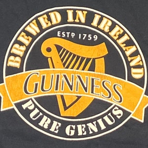 May include: A black and gold Guinness beer logo with the text "Brewed in Ireland" and "Est. 1759" around a harp. The text "Guinness" is in a large font and the text "Pure Genius" is in a smaller font.
