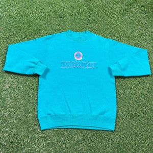 May include: A turquoise blue sweatshirt with a pink and white embroidered logo that says "Longboat Key".