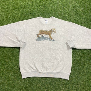 May include: A gray sweatshirt with a tiger graphic on the front. The tiger is brown and orange with black stripes.