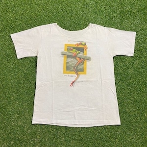 May include: White t-shirt with a graphic of two frogs on a branch, framed in yellow. The shirt displays the text "National Geographic" and "tree huggers."