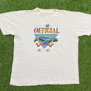 May include: White t-shirt with a graphic of a whale and the text "World Watch Official Save Our Whales Foundation".