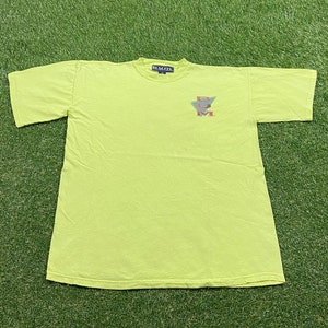 May include: A neon yellow t-shirt with a graphic of a triangle with the letters "R.U.M." inside. The letters are in red, blue, and green.