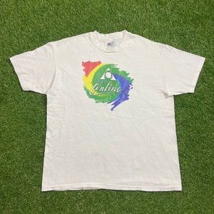 May include: White t-shirt with a colorful graphic of a triangle with the text "America Online" inside. The graphic is surrounded by a rainbow-colored swirl.