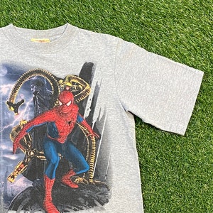 May include: Grey t-shirt featuring a graphic print of Spider-Man battling Doctor Octopus. The graphic is detailed and shows a dynamic pose of the two characters.
