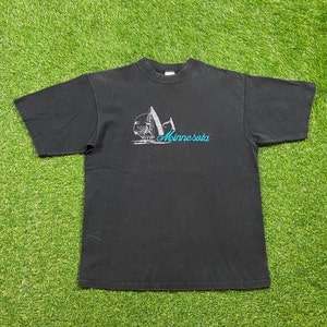May include: Black t-shirt with a white graphic of sailboats and the text "Minnesota" in blue.