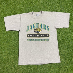 May include: A gray t-shirt with the Jacksonville Jaguars logo, the text "Jaguars", "Fred Taylor 28", and "National Football League".