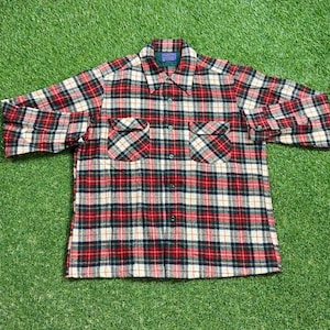 May include: A red, white and black plaid flannel shirt with a button-down collar and two chest pockets.