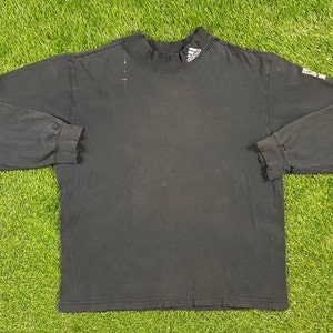 May include: A black long-sleeved mock neck shirt with the Adidas logo on the front.