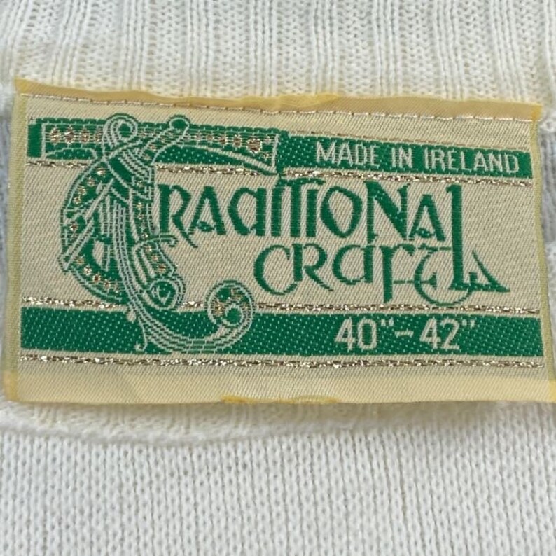 May include: A white label with green and gold trim. The label reads "Made in Ireland", "Traditional Craft", and "40" - "42".